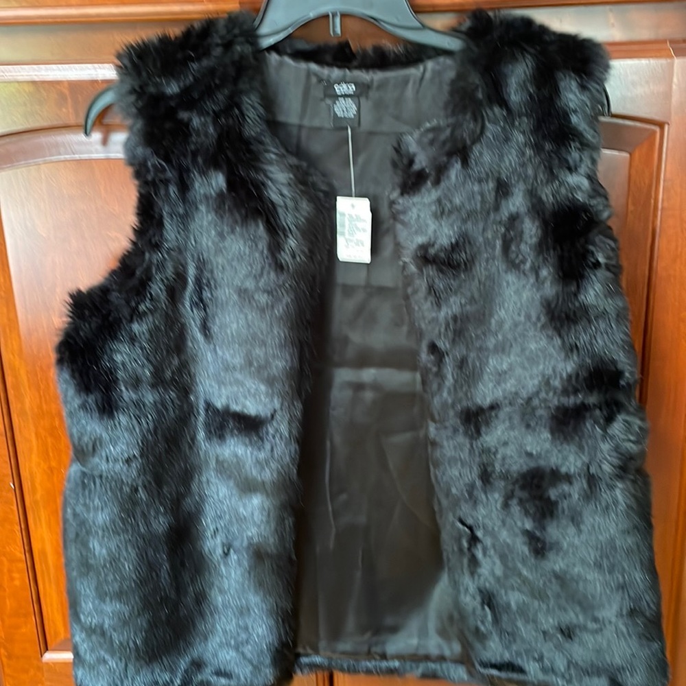 Black Faux Fur vest with pockets. New with tags. 27 inches long.  Great fun!